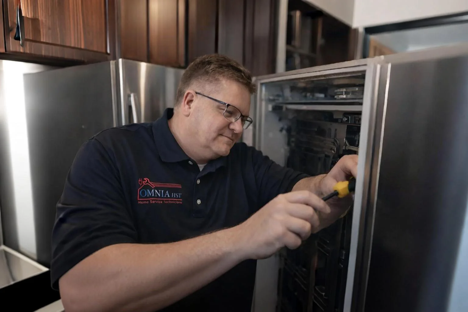 Omnia HST Home Service Technicians appliance repair technician servicing a home in North Alabama and Southern Tennessee